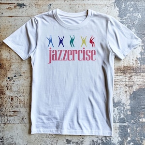 May include: White t-shirt with a pink "jazzercise" logo and a row of colorful stick figures in various poses.