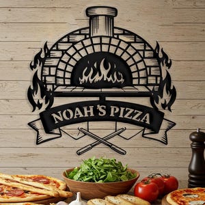 May include: Black metal sign with a brick oven design and flames. The sign says "Noah's Pizza" with crossed pizza peelers underneath. The sign is hanging on a wood wall with pizzas and other food items on a table in front of it.