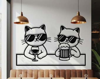 May include: Black and white wall art featuring two cartoon cats wearing sunglasses. One cat is holding a glass of wine, and the other is holding a beer. The cats are sitting at a bar counter.