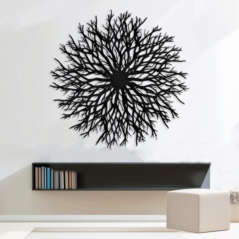 May include: Black metal wall decor in the shape of a large, circular, branching tree. The decor is mounted on a white wall above a black shelf with books.