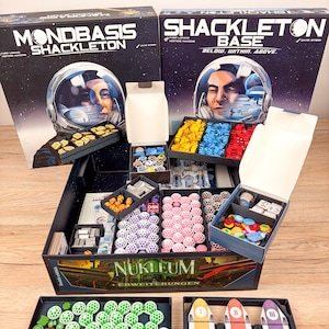 以下が含まれることがあります： Mondbasis ShackletonおよびShackleton Base用のボードゲームオーガナイザーセット。黒いプラスチック製のトレイに、黄色、青、赤、ピンク、緑のトークンなど、さまざまなゲームコンポーネントが収納されており、ゲームボックスも含まれています。