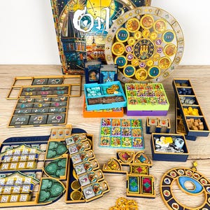 May include: A board game set titled Orl featuring a large circular astronomical clock dial, a game box, player boards, colorful square tiles, small wooden resource tokens, and various plastic trays for organizing game components.