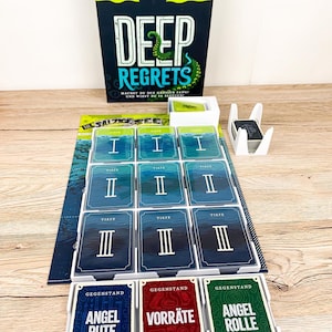 Könnte beinhalten: Brettspiel "Deep Regrets" mit einer Box, die ein Schiff und den Titel des Spiels zeigt. Das Spiel enthält Karten mit römischen Ziffern und Text sowie Karten mit der Aufschrift "Angel Rute", "Vorräte" und "Angel Rolle".