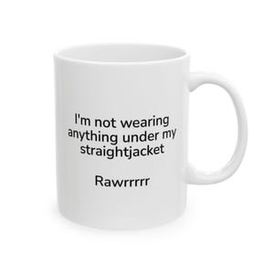 May include: White ceramic mug with black text that reads "I'm not wearing anything under my straightjacket Rawrrrrrr".