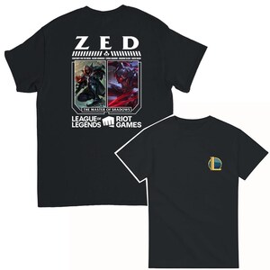 Peut inclure: T-shirt noir avec un graphique blanc du personnage Zed de League of Legends. Le graphique présente le nom de Zed, le texte "The Master of Shadows" et le logo de League of Legends. Le dos du t-shirt a un logo League of Legends plus petit.