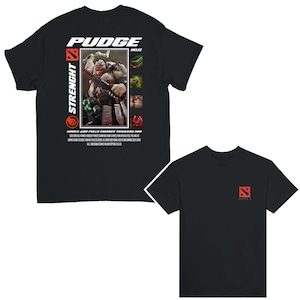 May include: Black t-shirt with a white graphic of Pudge, a character from the video game Dota 2. The graphic includes the text "Pudge", "Strength", "Melee", and "Hooks and pulls enemies towards him".