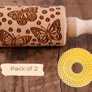 Peut inclure: Un rouleau à pâtisserie en bois avec un motif de papillon et le texte "Pack of 2". Le rouleau à pâtisserie est sur une surface en bois avec un emporte-pièce en plastique jaune.