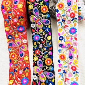 Galon brodé papillons et fleurs 7,5 cm – ruban coloré sur fond rouge, noir ou blanc pour vêtements, sacs et déco textile.