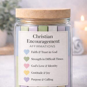 Puede incluir: Un tarro de cristal con tapa de madera, etiquetado como "Christian Encouragement AFFIRMATIONS". La etiqueta enumera afirmaciones como "Faith & Trust in God" y "Strength in Difficult Times". El tarro contiene tiras de colores pastel.