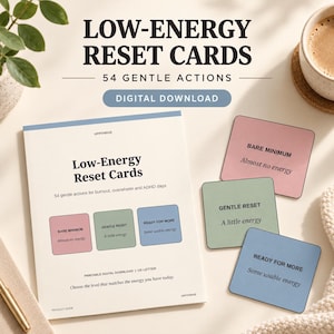 Könnte beinhalten: Ein Set von Low-Energy Reset Cards mit 54 sanften Aktionen. Das Produkt enthält einen Leitfaden sowie einzelne Karten in Rosa, Grün und Blau, beschriftet mit Bare Minimum, Gentle Reset und Ready for More für verschiedene Energieniveaus.