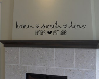 May include: Black and white home sweet home wall decal with the text "Herres Est 1998" below. The decal is placed above a fireplace.