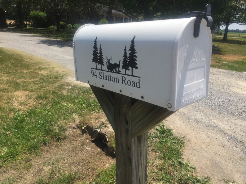May include: White mailbox with a black silhouette of trees and a deer on a white background. The mailbox has the text "94 Slatton Road" printed on it.