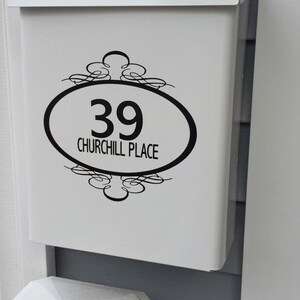 May include: White mailbox with a black oval sticker that says "39 CHURCHILL PLACE" with a decorative design above and below the oval.
