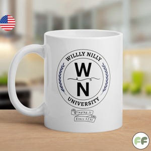 May include: A white ceramic mug featuring a circular black and blue emblem with the text WILLY NILLY UNIVERSITY and the letters W N in the center. Below the emblem is a banner with the text Winging it Since 1231 in a black serif font.