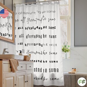 May include: White shower curtain with black text that reads "We are all different and the same." The curtain is hanging in a bathroom with a vanity and a window.