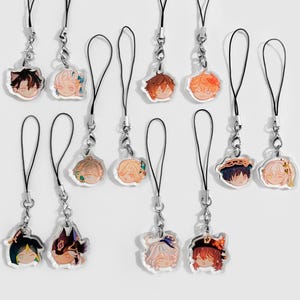 May include: Twelve colourful character charms with black string phone charms. The charms are round and feature different anime characters with various expressions.