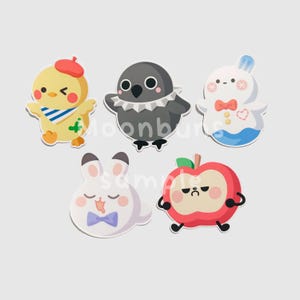 May include: A collection of five cartoon character stickers. The stickers include a yellow chick with a red beret, a gray bird with a white collar, a white bunny with a blue bow tie, a white bunny with a blue bow tie, and a red apple with a face.