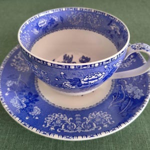 Könnte beinhalten: Blau-weißes Porzellan-Tee-Set. Die Tasse und Untertasse weisen ein Blumenmuster mit aufwendigen Details auf. Das Set besteht aus Keramik und eignet sich zum Servieren von Tee oder Kaffee. Die Tasse hat einen Henkel.