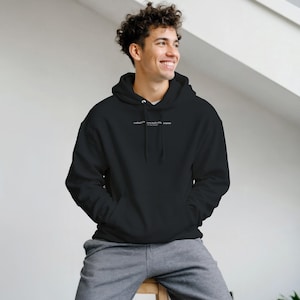 Può includere: Una felpa con cappuccio nera dotata di una tasca a marsupio frontale e maniche lunghe. Sulla zona del petto è presente una piccola scritta bianca che recita "crafted with care built with purpose". La felpa presenta un cappuccio con coulisse.
