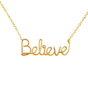 May include: A gold necklace with the word "Believe" spelled out in cursive.
