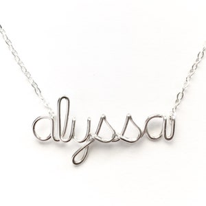 May include: A silver necklace with the name "Alyssa" spelled out in wire.