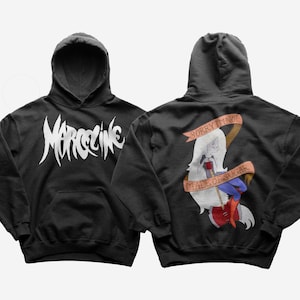 Pode incluir: Camisola de moletom com capuz preta com um gráfico branco da palavra "MARCELINE" na frente e um gráfico branco de um personagem de desenho animado com o texto "SORRY I'M NOT MADE OF SUGAR" nas costas.