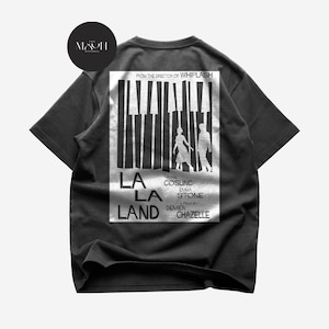May include: A black short-sleeve t-shirt featuring a white graphic print on the back. The design displays piano keys, silhouettes of two people, and the text: FROM THE DIRECTOR OF WHIPLASH, LA LA LAND, RYAN GOSLING, EMMA STONE, A FILM BY DAMIEN CHAZELLE.