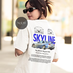 May include: White t-shirt with a blue and white graphic of a Nissan Skyline R34 car. The text "SKYLINE" is printed in blue above the car. The text "The Nissan Skyline R34 - Nissan has a rich history" is printed below the car.
