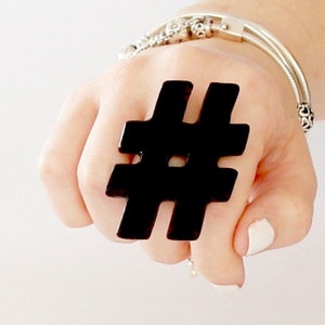May include: A black plastic ring shaped like a hashtag symbol.