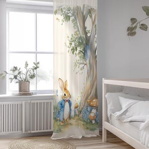 May include: A sheer white curtain with a watercolor illustration of a rabbit in a blue jacket standing in a forest with a large tree and mushrooms.