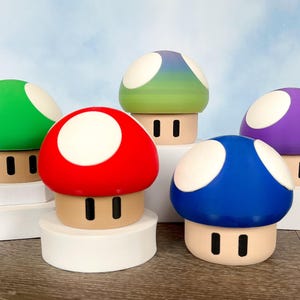 May include: Five colorful mushroom-shaped figurines with white spots on top. The mushrooms are green, red, blue, purple, and a gradient of green and blue.