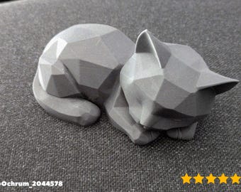 May include: A gray geometric cat sculpture in a resting pose. The cat is made of angular shapes, giving it a modern, minimalist look. The sculpture is resting on a textured gray surface.