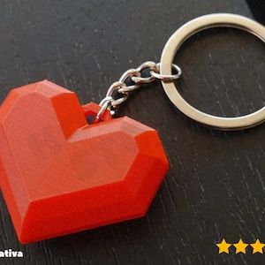May include: A red, geometric heart-shaped keychain. The heart is attached to a silver chain and keyring. The keychain is made of a solid material and has a faceted design. The Etsy shop name "@3d_creativa" is visible in the bottom left corner.