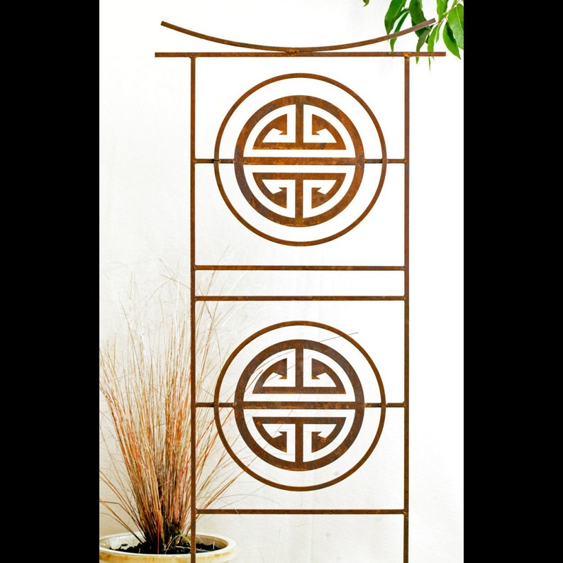 May include: A rusty metal garden trellis with two decorative circles featuring a traditional Chinese symbol. The trellis is designed to support climbing plants.