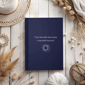 May include: A navy blue journal with the quote "You rise with the moon, I rise with the sun" and a white sun and moon graphic.