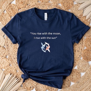 May include: A navy blue t-shirt with the text "You rise with the moon, I rise with the sun" and a graphic of two koi fish.