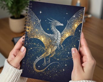 May include: A spiral bound notebook with a silver dragon flying against a dark blue background with gold glitter. The dragon's wings are spread wide and its tail is curled around its body. The background is filled with stars and glitter.