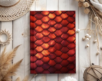May include: A red and orange notebook with a scale pattern cover. The notebook is lying flat on a white wooden surface.