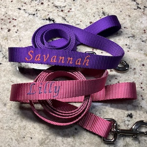 May include: Two dog leashes, one purple and one pink, with the names "Savannah" and "Lilly" embroidered on them.