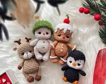 Könnte beinhalten: Eine Sammlung handgefertigter Weihnachtsornamente aus Häkelarbeit. Das Set beinhaltet ein Rentier, einen Schneemann, einen Lebkuchenmann und einen Pinguin. Jedes Ornament ist mit detaillierten Nähten und leuchtenden Farben gefertigt.