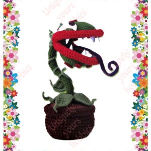 May include: A crocheted plush toy of a carnivorous plant with a large red mouth, green leaves, and a purple tongue. The plant is in a brown pot.
