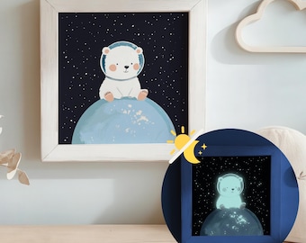 Puede incluir: Un oso polar blanco con un casco espacial se sienta en un planeta azul en un espacio azul oscuro con estrellas blancas. La imagen está enmarcada en un marco blanco. La imagen brilla en la oscuridad.
