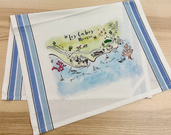 May include: A white kitchen towel with blue stripes features a hand-drawn map of Los Cabos, Mexico. The map includes landmarks such as Lover's Beach, the Marina, and the Sea of Cortez. The towel is ideal for adding a touch of coastal charm to your kitchen.