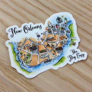 May include: A watercolor illustration of a map of New Orleans, Louisiana. The map features landmarks like the Superdome, Harrah's Casino, and the French Quarter. The text "The Big Easy" is written in the bottom right corner of the map.