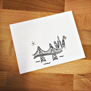 May include: A black and white line drawing of a bridge with a cityscape in the background. The sun is shining in the upper left corner of the image.