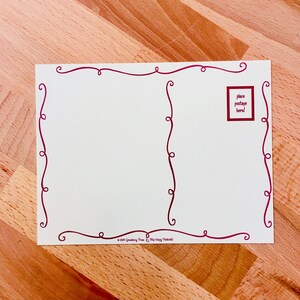 May include: A white postcard with a red border. The border is made of a series of swirls. The postcard has a space for a stamp in the upper right corner. The text "place postage here!" is printed in a red box.