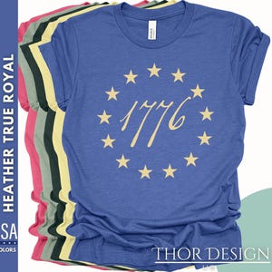 May include: A blue t-shirt with a circle of stars and the text "1776" in a cream colour.