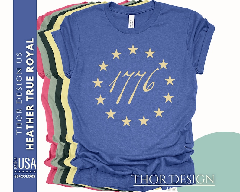 May include: A blue t-shirt with a circle of stars and the text "1776" in a cream colour.
