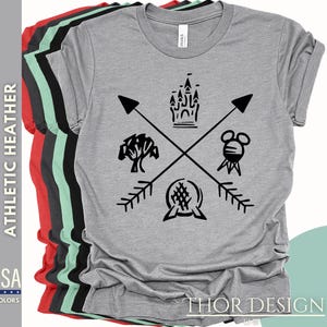 May include: A heather grey t-shirt with a black graphic design featuring a castle, a tree, a Mickey Mouse head, and a sphere with a cross pattern. The graphic is surrounded by four arrows pointing in different directions. The text "THOR DESIGN" is printed on the bottom of the shirt.