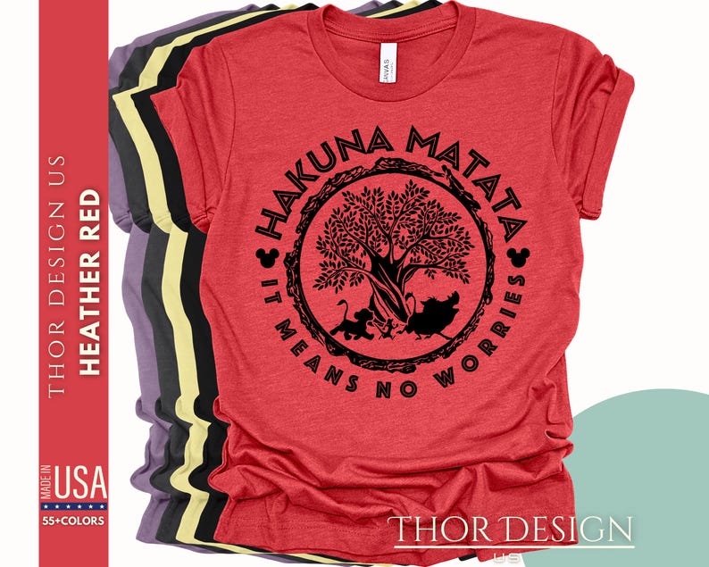 Puede incluir: Camiseta roja con un gr&aacute;fico circular negro que presenta un &aacute;rbol, las palabras "Hakuna Matata" y la frase "It means no worries".
